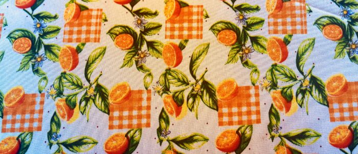 Fresh oranges on a patterned tablecloth